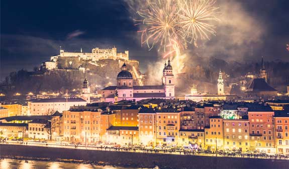 Feuerwerk über der Stadt Salzburg, leuchtende Farben erhellen den Nachthimmel und schaffen eine festliche Atmosphäre.